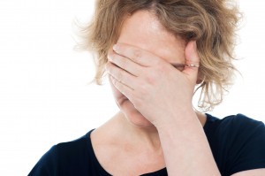 Unhappy woman hiding her face with hand on it
