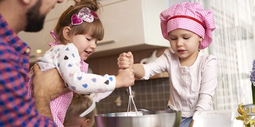 Daughters helping father with cooking